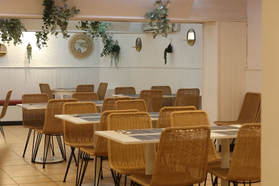 Sala ampla preparada com mesas corridas para um jantar de grupo